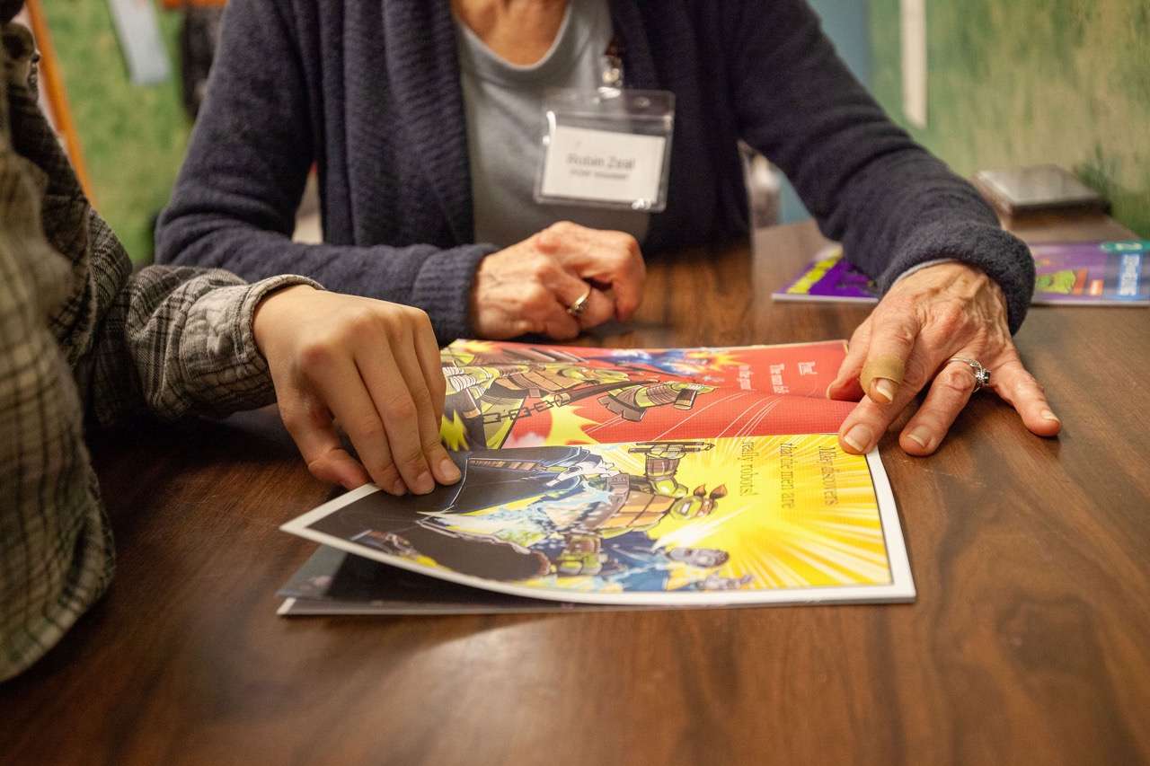 A reader and volunteer choosing a colorful book together