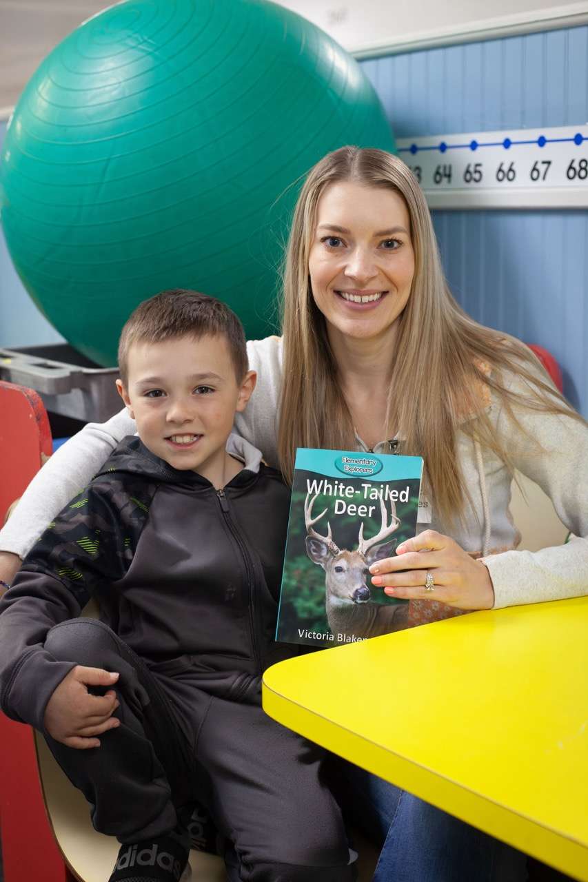 A ROW volunteer and young reader sharing a book together