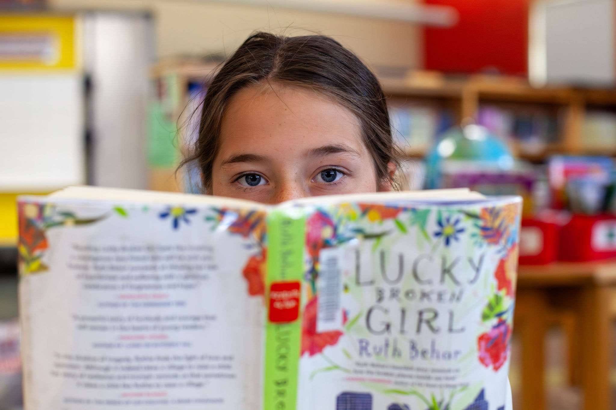 A child reading with support from a ROW volunteer